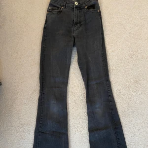 Svarta bootcut jeans - Säljer ett par svarta jeans med bootcut-modell. Jeansen har klassisk femficksdesign, knapp och dragkedja fram samt bälteshällor. Snygg mörk tvätt och stretchigt jeanstyg som sitter skönt i midjan och över höfterna. Säljer dem eftersom de är för små för mig tyvärr. (Är 168cm men har långa ben)
