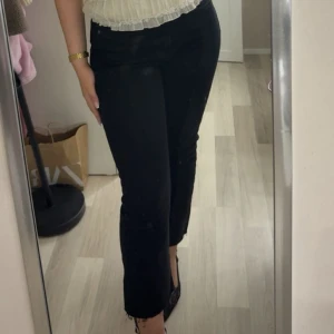 Svarta croppade jeans - Snygga svarta jeans med croppad längd och råa benslut. Byxorna sitter tajt över höfterna med en rakare passform nedtill. Perfekta att matcha med klackar eller sneakers.