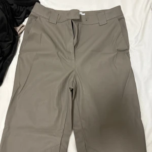 Beiga skinnbyxor Claire Rose x NA-KD - Snygga beiga skinnbyxor från Claire Rose x NA-KD i rak modell. Byxorna har bälteshällor, dragkedja och raka ben. Perfekta för dig som vill ha en clean och trendig look med lite edge.