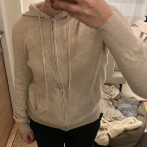 Beige hoodie i kashmir från Soft Goat - Supermjuk beige hoodie från Soft Goat i 100% kashmir. Tröjan har dragkedja framtill, huva med snören och två fickor. Några få skavanker vid resåren men de syns inte eftersom de är så små. Passar även xs-s ❤️