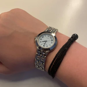Silverfärgad klocka från Attwood - Stilren klocka från Attwood med silverfärgad länkarmband och rund vit urtavla. Klockan har romerska siffror och klassisk design som passar till många olika stilar. Bra skick! 💕