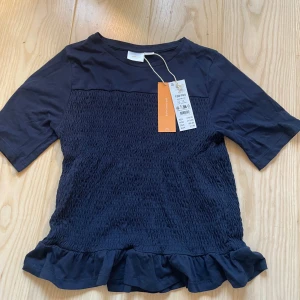 Mörkblå smockad topp med volang - Supersöt mörkblå topp från Gina Young ❤️ Helt ny med prislapp kvar. Nypris 220 kr🥰