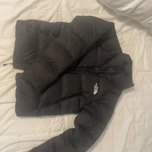 Svart dunjacka The North Face XS - Säljer en svart dunjacka från The North Face i modell Hyalite Down. Jackan är puffig med hög krage, dragkedja framtill och logga på bröstet och ryggen. Inga tecken på användning då jag använt den väldigt lite. 