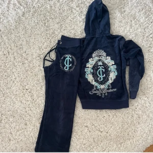 Mörkblå Juicy Couture hoodie i velour - 2000s Juicy Couture hoodie och byxor i mörkblå velour med stora JC-loggor och glittriga detaljer på ryggen. Tröjan har huva, långa ärmar och ribbade muddar.💋