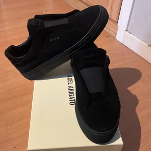 Svarta sneakers från Axel Arigato - Stilrena svarta sneakers från Axel Arigato i mocka med elastisk panel över vristen för en clean look.