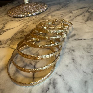 Guld armband nya set 7 st - Fina armband helt nya, ett set 7 st dem är justerbara i guldfärgad metall.