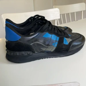 Valentino Rockrunner blå/svart - Tja. Ja säljer mina valentino rockrunners i storlek 43, Då de inte passar längre. Skick 8/10. De har inga större defekter förut att sulan har låssnat lite längst fram på en av skorna men de är ingenting som syns. Tveka inte på att höra av dig vid minsta fundering!