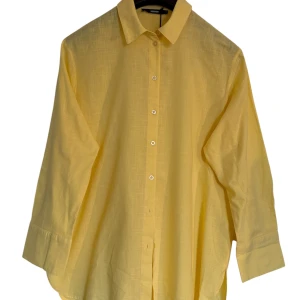 Gul skjorta  från Bik Bok - Ljusgul skjorta från Bik Bok i luftig bomull perfekt för varma dagar. Klassisk krage, knäppning framtill och långa ärmar med manschett. Skjortan har en loose fit och ger en fräsch och somrig vibe.