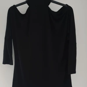 Svart offshoulder topp från Only - Svart offshoulder topp från Only med hög hals och trekvartsärm. Snygg och stilren modell som passar perfekt när du vill sticka ut lite extra. Mjuk och stretchig känsla, lätt att matcha med både jeans och kjol.  Helt & fint skick, tvättludd
