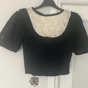 Svart och vit blus från Zara - Supersöt svart/vit blus/topp från Zara med croppad passform, puffiga korta ärmar och vit spets upptill. Skick 10/10