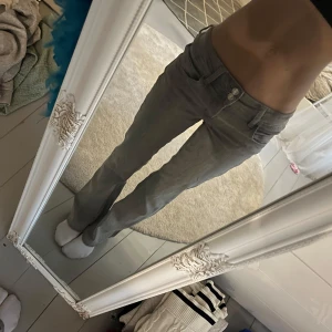Grå bootcut jeans med låg midja - Säljer ett par grå jeans med låg midja från Gina tricot.