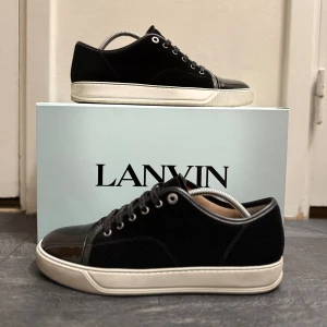 Lanvin Cap Toe - Riktigt schyssta Lanvin Cap Toe DBB1 i svart mocka. Storlek 43. Skorna är i toppskick!! Box, dustbag och extra par skosnören tillkommer i boxen. Finns inga skador på skorna. Hör av dig vid intresse, pris går och diskuteras. 
