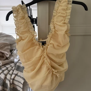 Gul volangig linnetopp i chiffong - Supersöt ljusgul linnetopp från Pretty Little Things med volangiga axelband och rynkade detaljer framtill. 