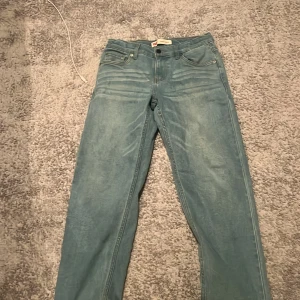 Levi's Loose Taper ljusblå jeans - Säljer ett par ljusblå Levi's Loose Taper jeans med klassisk femficksdesign och röd Levi's-tag på bakfickan. Jeansen har en loose passform med avsmalnande ben och är tillverkade i mjukt denim. Perfekt för dig som gillar avslappnad stil och snygga detaljer. Storlek 14-15 år! 164cm!
