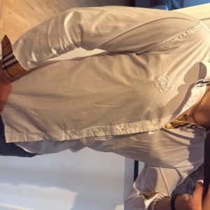 Vit Burberry skjorta med rutig detalj - Snygg vit skjorta  med klassiska rutiga detaljer på insidan av kragen, knappslån och manschetterna. Skjortan har använts en gång och därför säljer jag den. Storlek medium men passar även på S. Skriv vid funderingar. Skriv innnan du köper !!!!!