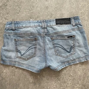 Blå jeansshorts från ONLY W29 - Snygga ljusblå jeansshorts från ONLY med detaljer på fickorna. De är low waist