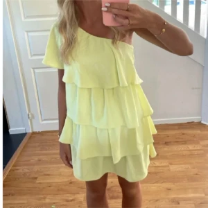 Gul klänning Zara - Säljer en ljusgul kortklänning med flera lager volanger och oneshoulder-design