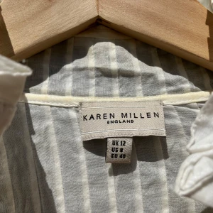 “Boho-dröm i vitt 🤍 – ett måste i garderoben!” - Karen Millen boho-blus 🤍 stl 40, men är som en stl.38 Drömmig vit boho-blus från Karen Millen – perfekt till jeans eller kjol! ✨ Spets- och broderidetaljer ✨ Volangkantad krage & djup V-ringning ✨ Långa ärmar med breda manschetter och klädda knappar  📏 Storlek: EU 40 💎 Skick: Mycket fint 💰 Pris: 400 kr (kan diskuteras)