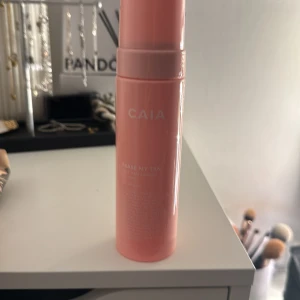 CAIA Erase My Tan face mist - Säljer en CAIA Erase My Tan face mist i en snygg rosa flaska med pump. Perfekt för att fräscha upp huden och ta bort överflödig brun utan sol. Flaskan är stilren och enkel att använda, passar bra i sminkväskan.