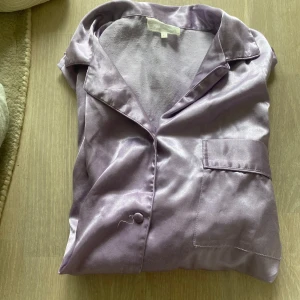 Ljuslila satinpyjamas - Säljer pyjamas sett med kortärmad skjorta och pyjamas shorts, storlek M men tycker att den passar de mesta storlekar🤍