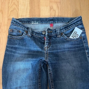Lågmidjade jeans - Snygga blå jeans med klassisk femficksdesign och bredare ben. Jeansen har låg midja, slitningar och fransad kant vid benslut för en cool vibe. Perfekt för dig som gillar tidlös streetstil.     !!Mått finns på bilderna!!
