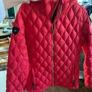 Canada Snow lättvikt dunjacka 40 - Jacka i nyskick. Vackert röd från canada snow. Storlek 40, passar även 38. 