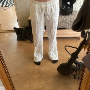 Vita linnebyxor med snörning - Säljer ett par chill vita linnebyxor med elastisk midja och snörning framtill. Byxorna har raka ben, fickor på sidorna och en bakficka. Perfekta för varma dagar och har en skön loose passform. Materialet är linne som ger en luftig och fräsch känsla. Köpte för 600 kr tror ja. Det finns exakt samma fast svarta med samma pris