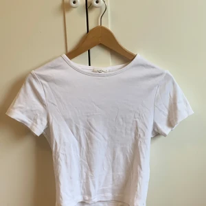 Vit kortärmad t-shirt - Topp från gina tricot! säljer då den inte kommer till använding, har använts typ en gång. skriv gärna om mer bilder!💗