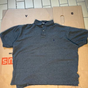 RALPH LAUREN PIKÉ i Grå - En grå Ralph Lauren piké i bra skick. Storlek en XL i man. Priset kan förhandlas!