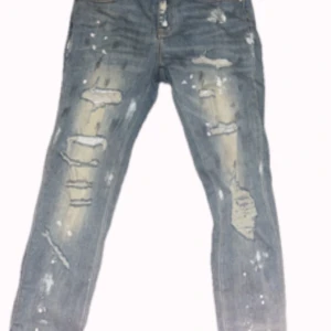 Blå slitna jeans från Amiri - Säljer ett par blå jeans från Amiri. De har flera slitningar och hål framtill. Perfekta för dig som vill ha en avslappnad men trendig look. Jag säljer de för att jag har ändrat min stil, annars de är skit snygga jeans