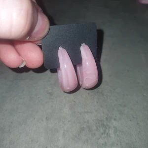 Rosa örhängen i bågform - Snygga rosa örhängen i bågform med en glansig yta. Perfekta för att ge en färgklick till din outfit. De är lätta och bekväma att bära hela dagen.