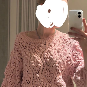 Rosa stickad tröja - Säljer en söt rosa stickad tröja med ett vackert hålmönster. Tröjan har långa ärmar och en rund halsringning. Perfekt för en mysig dag. Hör av er vid frågor eller prisförslag 💞