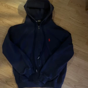 Mörkblå hoodie från Polo Ralph Lauren - Säljer en snygg mörkblå zipup hoodie från Polo Ralph Lauren i storlek M. Dock skulle ja säga att den passar S!!!!