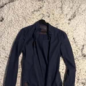 Mörkblå skjorta Slim fit - Snygg mörkblå skjorta från Crocker i slim fit. Skjortan har långa ärmar och knappar framtill. Skjortan har en grym passform och gjord med hög kvalité. Passar perfekt till dig som söker unik och stilren skjorta.Passar folk runt 170-184. Har inga tecken på användning. Skriv vid funderingar!