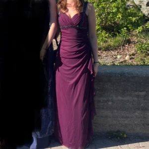 Lila balklänning  - Jättefin lila balklänning med volanger och pärldetaljer! Den har även en öppen rygg effekt och passar mig perfekt som är 173 cm. I övrigt så passar den storlek S 💕 Skriv för fler bilder eller frågor!