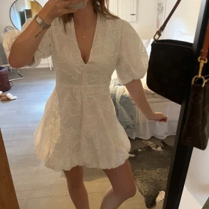 Student klänning  - Säljer en vit kortklänning med puffiga kortärmar och v-ringning. 🌸                         Klänningen är endast testad då den var tänkt till studenten 