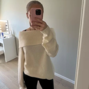 Vit offshoulder tröja från Bik Bok - Säljer en stilren crémevit offshoulder tröja från Bik Bok. Tröjan har långa ärmar och en bred ribbad kant vid halsen. Den är lång i modellen men går att vika upp. Storlek xs men är dock väldigt stor i storleken. Den är helt ny med prislapp kvar.