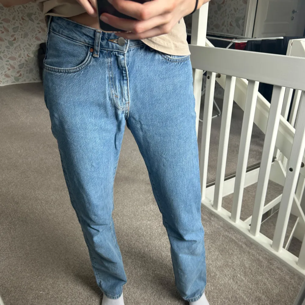 Säljer ett par klassiska blå jeansbyxor med normal passform. De har en rak stil och är tillverkade i jeansmaterial. Perfekta för en avslappnad look.. Farkut & Housut.