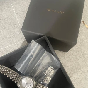 Silverfärgad klocka från GANT - Säljer en elegant silverfärgad klocka från GANT med en klassisk länkarmband och stilren urtavla och kommer i originalförpackning. Jag säljer den eftersom ja fick den i present och andvänder mig bara av guld smycken. Köpte den av ungefär 1800kr och säljer den för 950. Priset kan alltid diskuteras.