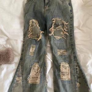 Rippade jeans med camouflage-detaljer - Flared