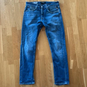 Blå jeans från Replay - Snygga blå jeans från Replay med en klassisk femficksdesign✅. Jeansen är i den populära modellen groover och i storlek 32/32👍. På vänstra benet finns väldigt populära och trendiga slitningar som absolut höjer byxornas utseende💯 skriv till mig vid frågor och funderingar😊jeansen har slitits i skrevet men inget hål. Detta kan fixas lätt tror jag