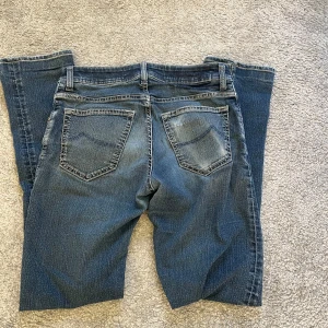 Blå jeans från Jacob Cohën - Säljer ett par snygga blå jeans från Jacob Cohën. De har en klassisk femficksdesign med knappar och en stilren look. Perfekta för dig som gillar en tidlös stil.