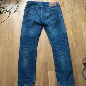 Levi's 501 jeans - Klassiska Levi's 501 jeans i blå färg. De har lite slitningar som kan ses på bilden och sitter perfekt. Storlek är W30 L30. Orginalpris = 1149