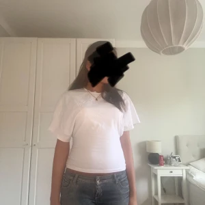 Vit kortärmad topp i bomull - Enkel och fräsch vit topp med korta ärmar och rund hals. Sitter figurnära och är gjord i mjuk bomull, perfekt till jeans eller kjol. Stilren och lätt att matcha med olika accessoarer.