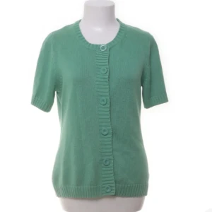 Cool grön stickad kofta med kort ärm - Snygg grön stickad kofta med korta ärmar och rund hals. Koftan har bred ribbad kant framtill och fem stora knappar som ger en chill vibe. Perfekt att slänga över en t-shirt för en fräsch look.