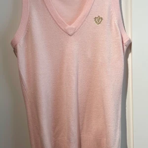 Ljusrosa stickad väst från Gina Tricot - Supersöt ljusrosa stickad väst från Gina Tricot med v-ringning och ribbade kanter. Är i gott skick💞