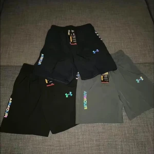 Under Armour shorts - oanvända - Säljer riktigt snygga och bekväma Under Armour träningsshorts, perfekta för gym, löpning eller sommaren generellt!  ✅ Nya med tag kvar ✅ Färger: svart, mörkgrå, ljusgrå ✅ Holografisk UA-logga + ”ARMOUR”-tryck i regnbågseffekt ✅ Mjukt, snabbtorkande funktionsmaterial ✅ Två sidofickor + resår i midjan med dragsko ✅ Lättviktiga och stretchiga – maxad komfort!  📏 Finns i storlek M,L,XL 💰 Pris: 250