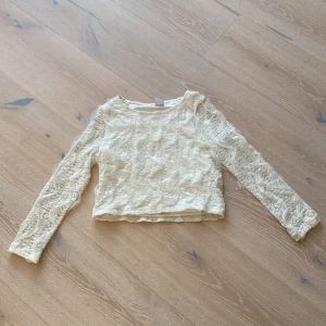 Vit spetsblus från Lindex Kids - Supersöt vit blus från Lindex Kids i storlek 128. Blusen är helt täckt av spets med långärmade ärmar och rund hals. Perfekt för dig som gillar romantiska och detaljerade plagg. Den är lätt croppad och har en mjuk innerdel för extra komfort.