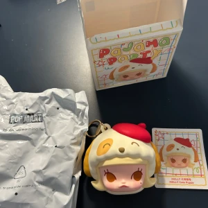 Pop mart Pajama Party: MOLLY Cute Puppy - Upptäck den söta och samlarvänliga MOLLY Cute Puppy från Pajama Party-serien! Perfekt för dig som gillar kawaii-design och vill ha en unik accessoar till väskan eller nyckelknippan. Färgglad, charmig och rolig – ett måste för unga samlare!