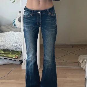 Low rise jeans - Snygga blå bootcut jeans från Weekday, modell Flame Low Flared. Jeansen har låg midja, klassisk femficksdesign och utsvängda ben. W.24 L.32